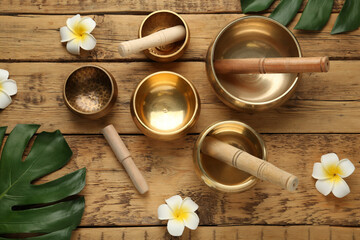 Flat lay composition with golden singing bowls on wooden table