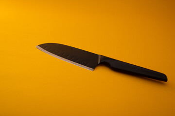 Knives made of metal, silver, lie on a yellow background