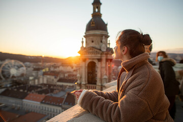 Fototapeta premium young woman on the tower looks at the city