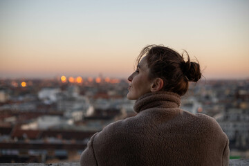 young woman on the tower looks at the city