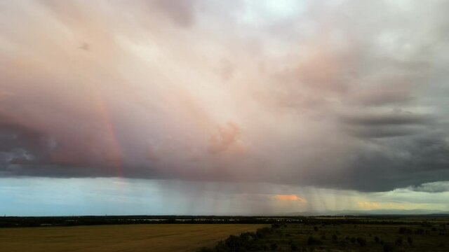 Landscape of dark clouds forming on stormy sky during thunderstorm over farmlands