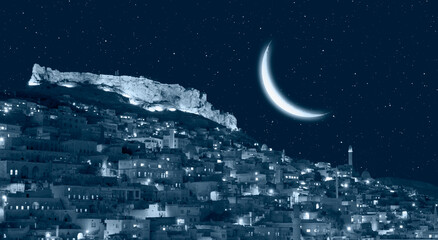 Obraz na płótnie Canvas Mardin old town at twilight blue hour Crescent moon in the background - Mardin, Turkey 