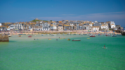 View of St. Ives town, Cornwall, England, from across the clear, blue water, on a sunny, summer's day. Room for copy.