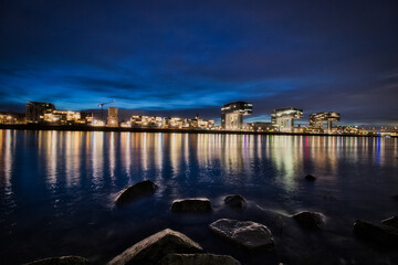 Cologne skyline with crane houses, dome and Rhine at the blue hour