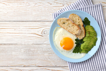 Plate of tasty breakfast on white wooden background