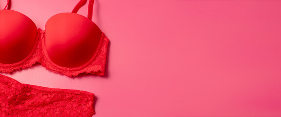 Beautiful female lacy panties and bra on pink background. Sexy red underwear. Banner with free...
