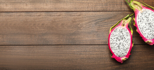 Delicious dragon fruit (pitahaya) on wooden table, flat lay with space for text. Banner design