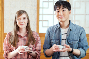 A foreigner and a Korean couple having a tea ceremony in a traditional Korean house