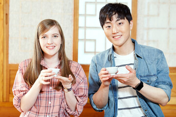A foreigner and a Korean couple having a tea ceremony in a traditional Korean house