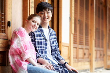 A young couple of a Western woman and a Korean man dating in a traditional Korean house