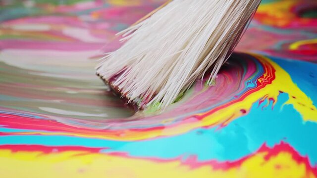Fiber of brush spreading layer of paint with colored stains