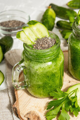 Green smoothie with cucumber in a glass jar. Fresh ripe vegetables, greens, and chia seeds