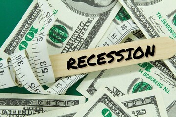 measuring tape and banknotes strewn with the word recession