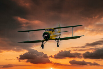 vintage biplane coming in to land at sunset