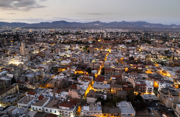 Aerial drone photograph of cityscape of Nicosia town in Cyprus at sunset. - obrazy, fototapety, plakaty