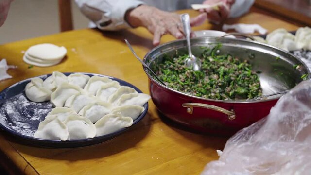 A Chinese family sitting together making dumplings