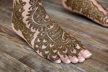 Henna art on the feet of Indian bride