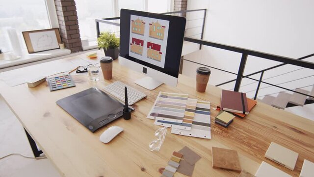 No people shot of architects workplace with material and color samples, graphic tablet and house sketch on computer monitor