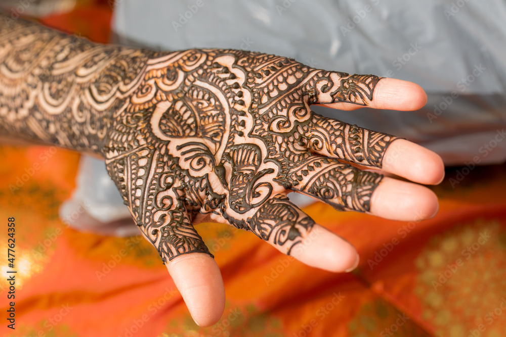 Wall mural drawing henna art on the hand of indian bride