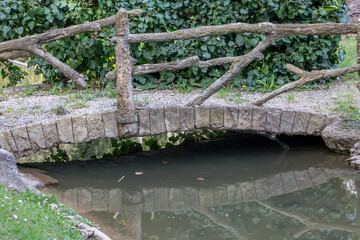 Fototapeta na wymiar pont et son reflet dans un jardin