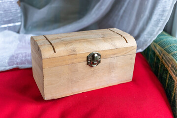 Wooden box on a red velvet cushion 