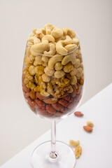 Glass jar filled with a variety of nutrition and healthy snacks and nuts on a white background