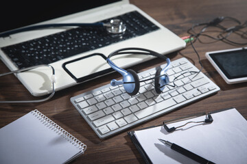 Telemedicine concept. Stethoscope, tablet, clipboard, headset with laptop.