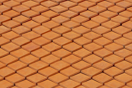 Selective focus of orange tiles pattern background, Details of modern red bricks, Shingles texture, Abstract geometric pattern, Roof top material.