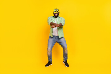 Full size photo of excited positive guy enjoy dancing crossed fists make moves toothy smile isolated on yellow color background