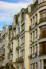 Fototapeta na wymiar Kyiv. Ukraine. July 1, 2021. Facade of colorful houses with windows, balconies on European street at summer or spring day. Residential buildings exterior. Classic architecture. Cityscape. City center.