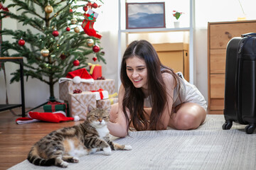 Obraz premium Young woman playing with cat on the floor at home.
