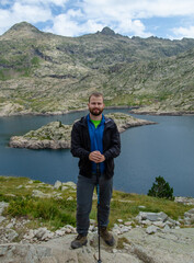A man posing at a lake in the mountain ,