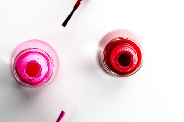 Opened bottles of nail polish on white background