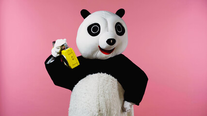 person in happy panda bear costume dancing with boombox isolated on pink.