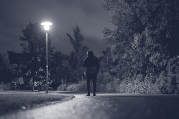 Hooded man walking alone in dark streets