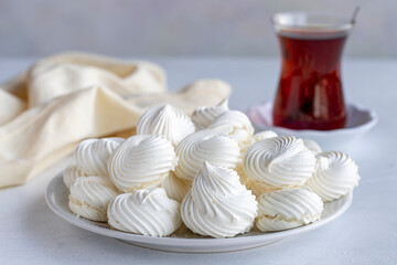 Small white meringues in a white dish. Macro shot. Horizontal view