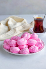 Small pink meringues in a white dish. Macro shot. Vertical view