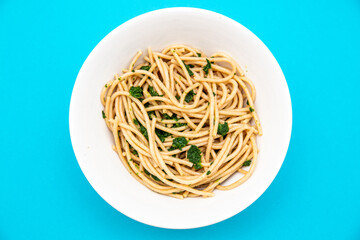 Top view of spinach pasta on cyan background
