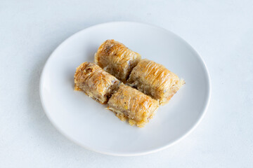 Walnuts baklava on a white plate. Turkish cuisine flavor baklava. Horizontal view.