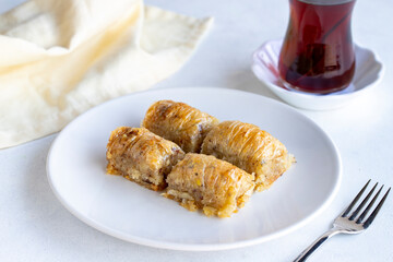 Walnuts baklava on a white plate. Turkish cuisine flavor baklava. Horizontal view.