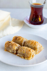 Walnuts baklava on a white plate. Turkish cuisine flavor baklava. Vertical view.