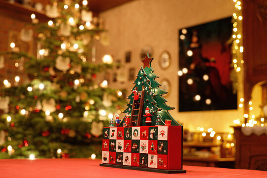 Dreidimensionaler Adventskalender mit stilisiertem Weihnachtsbaum inmitten eines weihnachtlich geschm&uuml;cktem Wohnzimmers