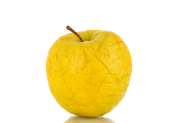 One yellow not very fresh apple, close-up, isolated on white.