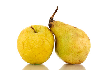 One yellow not very fresh apple and one ripe pear, close-up, isolated on white.