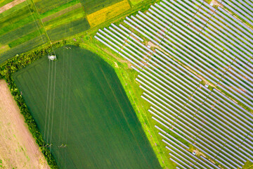 Aerial view of solar power plant on green field. Electric panels for producing clean ecologic energy