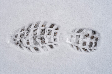 Shoe print on fresh wet snow in winter season