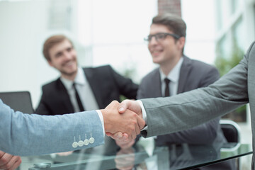 handshake of business people on a blurred office background.