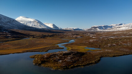 Valley with lake surrounded by snowy peaks at sunny day with no clouds. Scandinavian autumn landscape. Kungsleden trail, Sweden