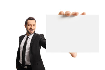 Cheerful young businessman holding a bland card in front of camera