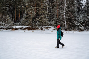 girl walking in the winter forest. Survival in the wild. Snow-covered forests. Walking in the winter season. Bright winter equipment